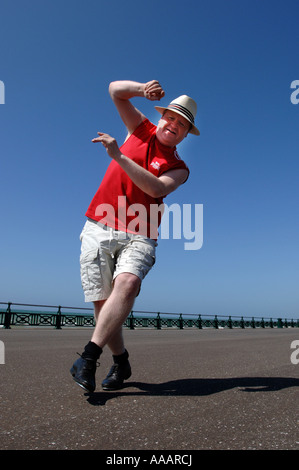 Un homme d'âge moyen de l'embonpoint se concentrant sur faire dur maladroit danse de routine sur le front de mer de Brighton Banque D'Images