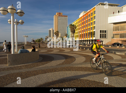 Israël Jérusalem Tel Aviv Beach promenade Vue avec cycliste à frgd et Dan hotel façade décorée par Yaaqov Agam dans bkgd Banque D'Images