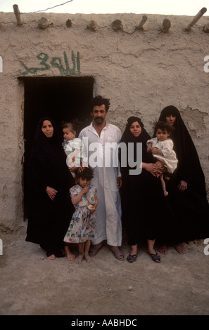 Marsh Arabes famille polygame Irak. Homme de famille avec trois épouses leurs enfants debout devant leur maison adobe sud de l'Irak des années 1984 1980 HOMER SYKES Banque D'Images