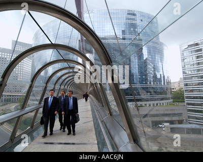 Trois hommes d'marche sur le pont couvert de verre à La Défense Paris France centre financier Banque D'Images