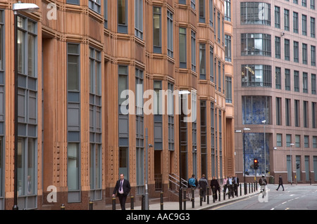 Les banlieusards éclipsées par de grands immeubles de bureaux du quartier financier de la ville de London UK Banque D'Images