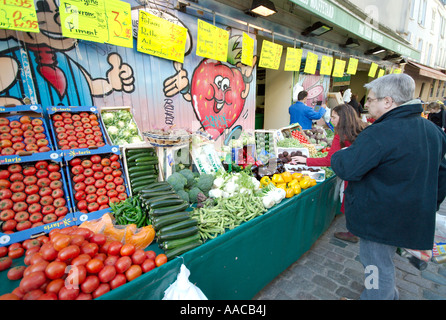 PARIS, France — Un marché parisien en plein air dynamique présente une gamme de produits frais. Les fruits et légumes colorés sont agencés avec art dans divers stands, tandis que les vendeurs et les acheteurs locaux interagissent dans cette scène traditionnelle du marché français. Banque D'Images