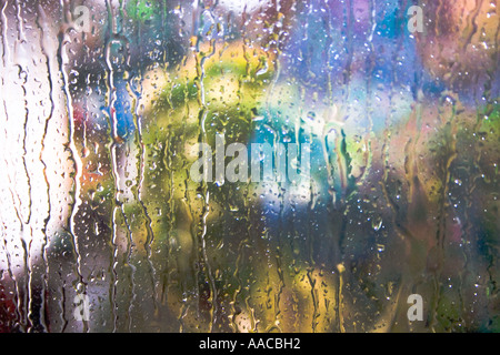 Vue sur un jardin par une fenêtre éclaboussé de pluie Banque D'Images