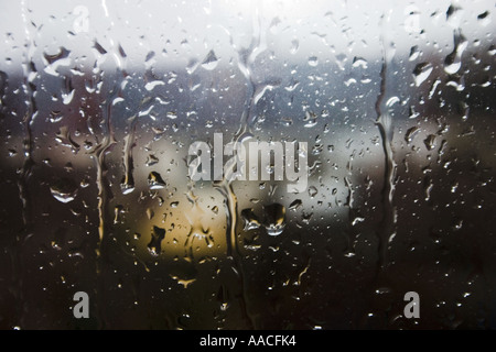 Vue sur un jardin par une fenêtre éclaboussé de pluie Banque D'Images