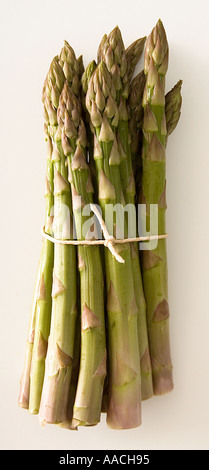 Asperges fraîches attachées avec une ficelle. Prise de vue depuis le haut sur un fond blanc prêt à être découpé. Banque D'Images