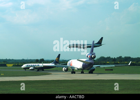 L'aéroport de Londres Stansted Ryanair passenger jet FedEx Freight avions en attente d'aéronefs entrant à la terre sur une seule piste principale Banque D'Images