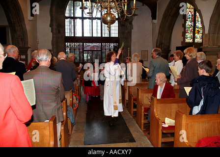 Femme prêtre en saupoudrant l'assemblée avec de l'eau baptismale - église anglicane - UK Banque D'Images
