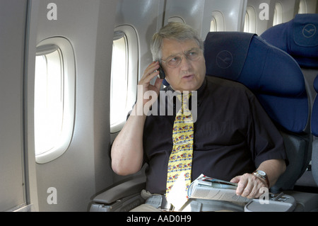 L'homme dans l'avion avec un téléphone mobile Banque D'Images