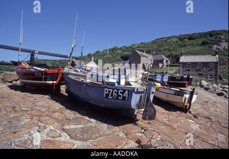 Penberth Cove sélection de petits bateaux de pêche assortis sur le pavage de pierre en pente abrupte avec des maisons de campagne au-delà du jour du ciel bleu ensoleillé Cornwall Angleterre Royaume-Uni Banque D'Images