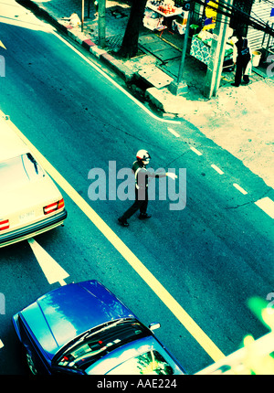 Policier thaïlandais de diriger le trafic important le long de la populaire Sukhumwit Road Bangkok Thaïlande comme il le fait pour les automobilistes vue de dessus et les traités Banque D'Images