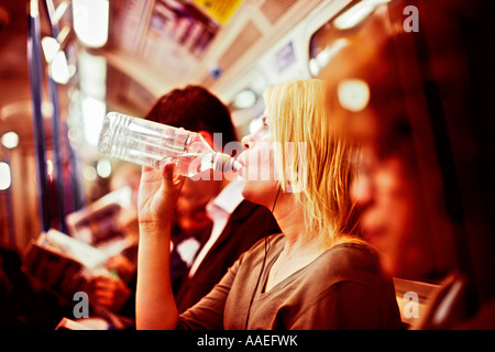 Sur le tube femme train prend un verre d'eau pendant des conditions torrides Banque D'Images