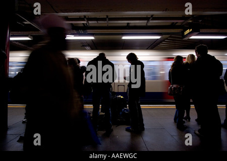 Réseau de métro de Londres avec les passagers sur la plate-forme avec le train accélérer passé Banque D'Images