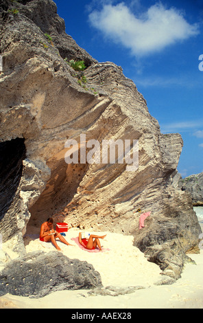 Les Bermudes La géologie historique plage rose couple relaxing on beach under rock formation Banque D'Images