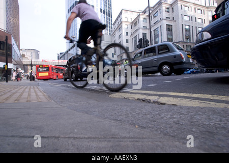 Vue en angle bas du cycliste sur la ligne jaune dans le centre de Londres pendant la ruée du soir avec la circulation Banque D'Images