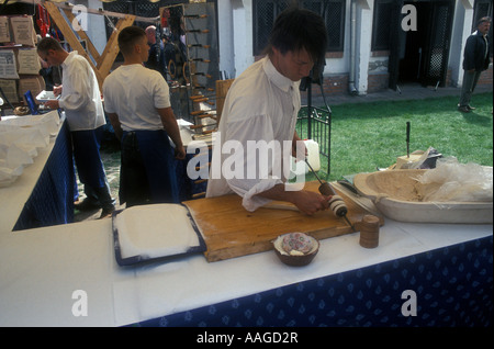 La préparation de kürtőskalács, un snack traditionnel, à l'Matyo festival de Pâques à Mezőkövesd, Hongrie Banque D'Images