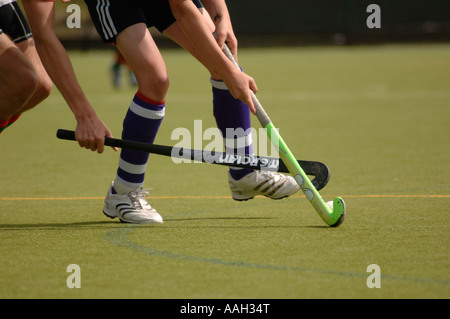 Deux hommes jouant dans un champ de hockey à l'université d'Aberystwyth au Pays de Galles ceredigion UK - un défi pour la balle sur ton plastique Banque D'Images