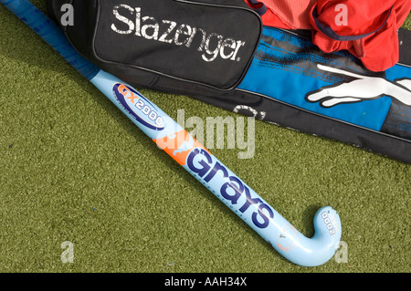 Bâton de hockey et gris sac de sport Slazenger reposant sur un gazon artificiel vert surface de jeu tous temps Banque D'Images