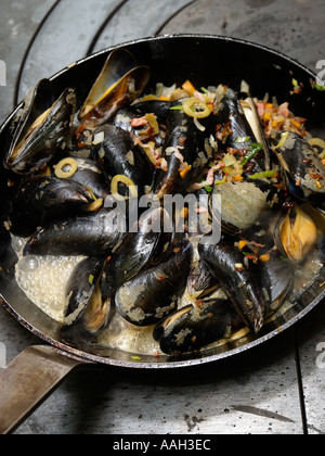 En préparation les moules avec les légumes et l'assaisonnement dans une casserole sur une cuisinière professionnelle Banque D'Images