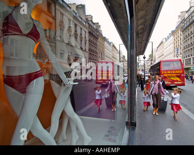 Scène de rue de mère qui voyage avec deux filles avec Galeries Lafayette vitrine dans Paris France Banque D'Images