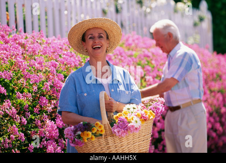 La collecte de couple smiling portrait jardin en fleurs Banque D'Images