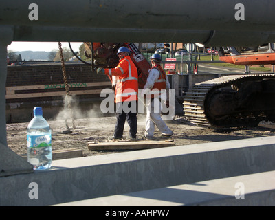 Deux ouvriers sur un chantier de wearing hard hards et Vêtements haute visibilité. Banque D'Images