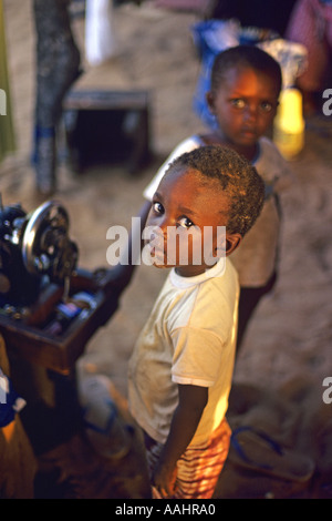 Les enfants gambiens debout par machine à coudre, à Banjul en Gambie en Afrique de l'Ouest JMH0672 Banque D'Images