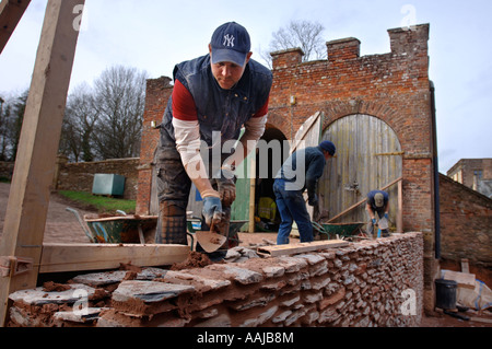 La construction d'un mur d'ARDOISE TRADITIONNELLE MORTE EN FACE D'UN BLOC STABLE CRÉNELÉ À HALSWELL MAISON PRÈS DE BRIDGWATER SOMERSET Banque D'Images