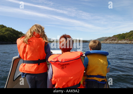 Famille en bateau sur un bateau à moteur sur le loch Sunart écossais en été le port de vêtements de sécurité Banque D'Images