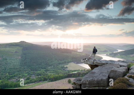 Homme Walker se tenait sur Bamford Edge affichage Ladybower reservoir au coucher du soleil dans le Derbyshire 'Grande-bretagne' Banque D'Images