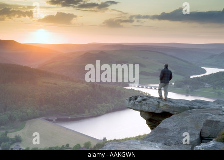 Homme Walker se tenait sur Bamford Edge affichage Ladybower reservoir au coucher du soleil dans le Derbyshire 'Grande-bretagne' Banque D'Images