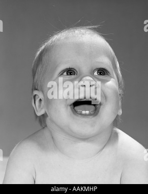 1960 Close-up PORTRAIT OF SMILING BABY BOY montrant deux premières dents dans la gencive inférieure Banque D'Images