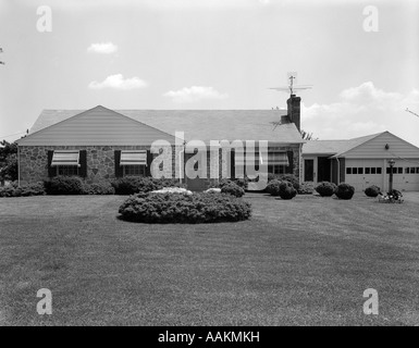 1960 SUR LA TÊTE TOURNÉ DE STYLE RANCH DE BANLIEUE Maison avec grande pelouse et garage 2 voitures Banque D'Images