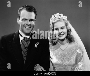 1940 Portrait de la jeune mariée et se toilettent lié bras dessus bras dessous LOOKING AT CAMERA Banque D'Images