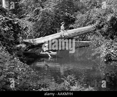 Années 1940 Années 1950 DEUX GARÇONS PORTANT DES CHAPEAUX DE PÊCHE DANS UN RUISSEAU Banque D'Images