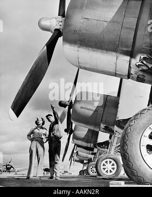 1940 WWII MARINE CORP TECHNICIEN À FEMME réserviste d'avions de chasse de l'INSPECTION SUR UN CHAMP DE L'AIR Banque D'Images