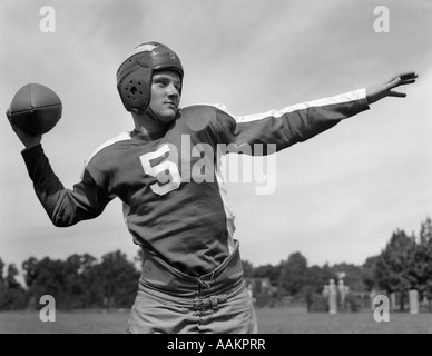 1940 YOUNG TEENAGE QUARTERBACK À PROPOS DE JETER LE FOOTBALL PASS Banque D'Images