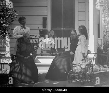 Années 1890 Années 1900 JEUNE ENFANT POUSSANT EN Poupée Poussette visiter trois femmes d'âge mûr assis dehors, portique de l'accueil Banque D'Images