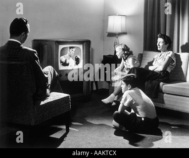 La famille des années 1950 DANS LE SALON EN REGARDANT LA TÉLÉVISION Banque D'Images