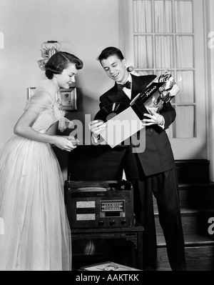 Années 1950, TEEN COUPLE Garçon et fille en jouant l'usure FORMELLE PROM PHONOGRAPH RECORDS Accueil Salle de séjour Banque D'Images