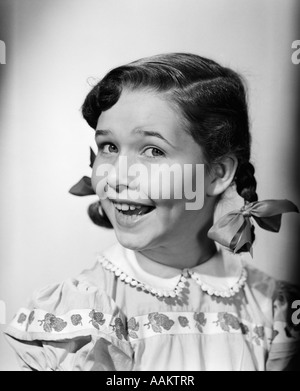 1950 SMILING GIRL PIGTAILS RIBBON BOW drôle de visage 34 PORTRAIT DE PROFIL Banque D'Images