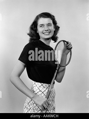 Années 1940 Années 1950 SMILING BRUNETTE WOMAN GIRL HOLDING BADMINTON RACKET Banque D'Images