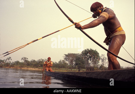 Xingu, forêt amazonienne, au Brésil. Yaulapiti les populations autochtones. Corps-indiens peints dans la pêche en canoë avec bow d'uneet flèche. Banque D'Images