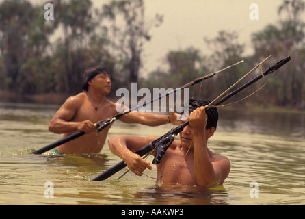 Xingu, forêt amazonienne, au Brésil. Yaulapiti les populations autochtones. Tuatuari river. Les jeunes indiens acculturés avec harpon de pêche. Banque D'Images