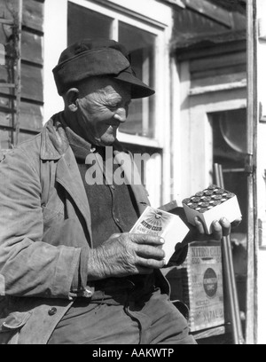 Années 1920 Années 1930 ALTÉRÉS ET PERSONNES ÂGÉES USÉS BARNEGAT BAY DUCK HUNTER Ouvrir boite de cartouches de fusil Banque D'Images