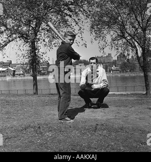 1950 Père et fils adolescent jouer au baseball dans CITY PARK Banque D'Images