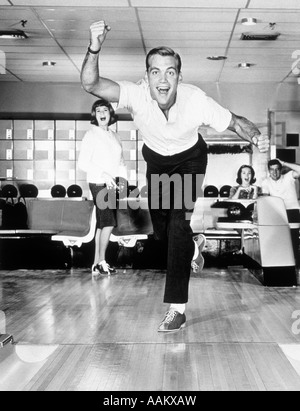 Années 1960 Années 1950 SMILING MAN MONTRANT UNE BONNE FORME EN BOWLING Banque D'Images