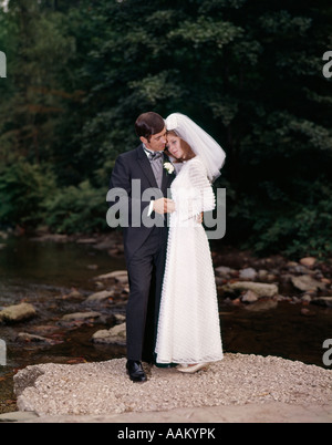 PORTRAIT DE LA JEUNE MARIÉE ET SE TOILETTENT DEBOUT SUR ROCK EN PLEIN AIR DU RUISSEAU Banque D'Images