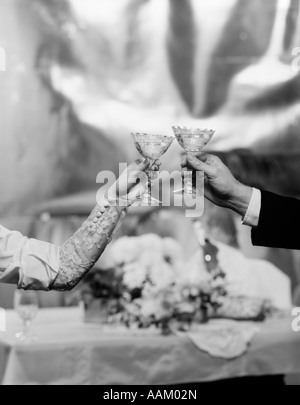 Mains et bras d'une Bride and Groom TOASTING WITH CHAMPAGNE GLASSES Banque D'Images