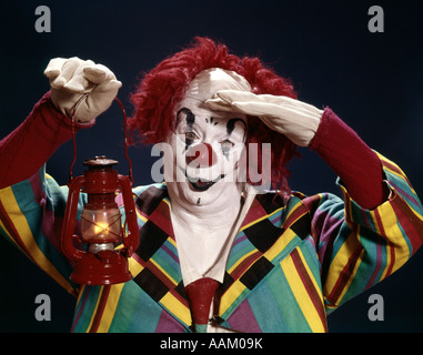 1960 VISAGE BLANC DE CLOWN PERRUQUE FIL ROUGE MOP NEZ ROUGE HOLDING LANTERN PART FRONT SALUTE SALUER RECHERCHE GANTS RECHERCHE Banque D'Images