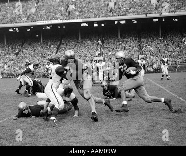 1950 College Football jeu montrant des bloqueurs s'attaque pour la course de retour avec foule de capacité dans les peuplements en arrière-plan Banque D'Images